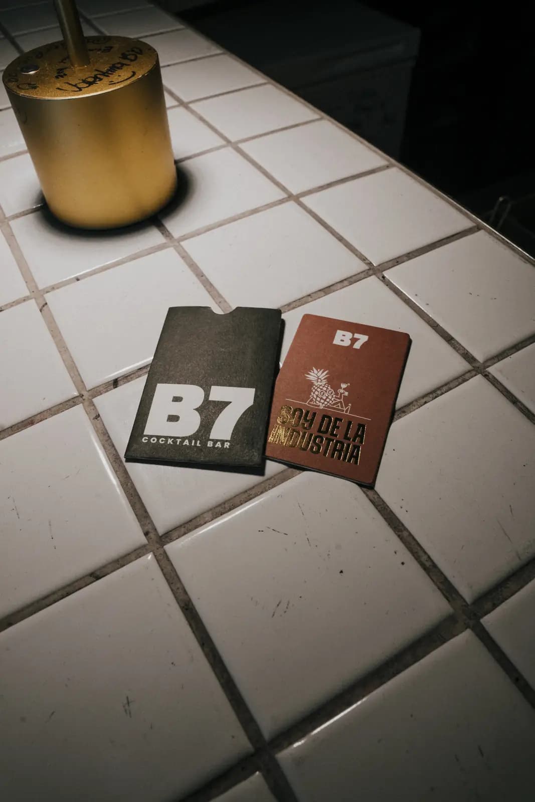 Posavasos con el monograma B7 sobre la baldosa de la barra