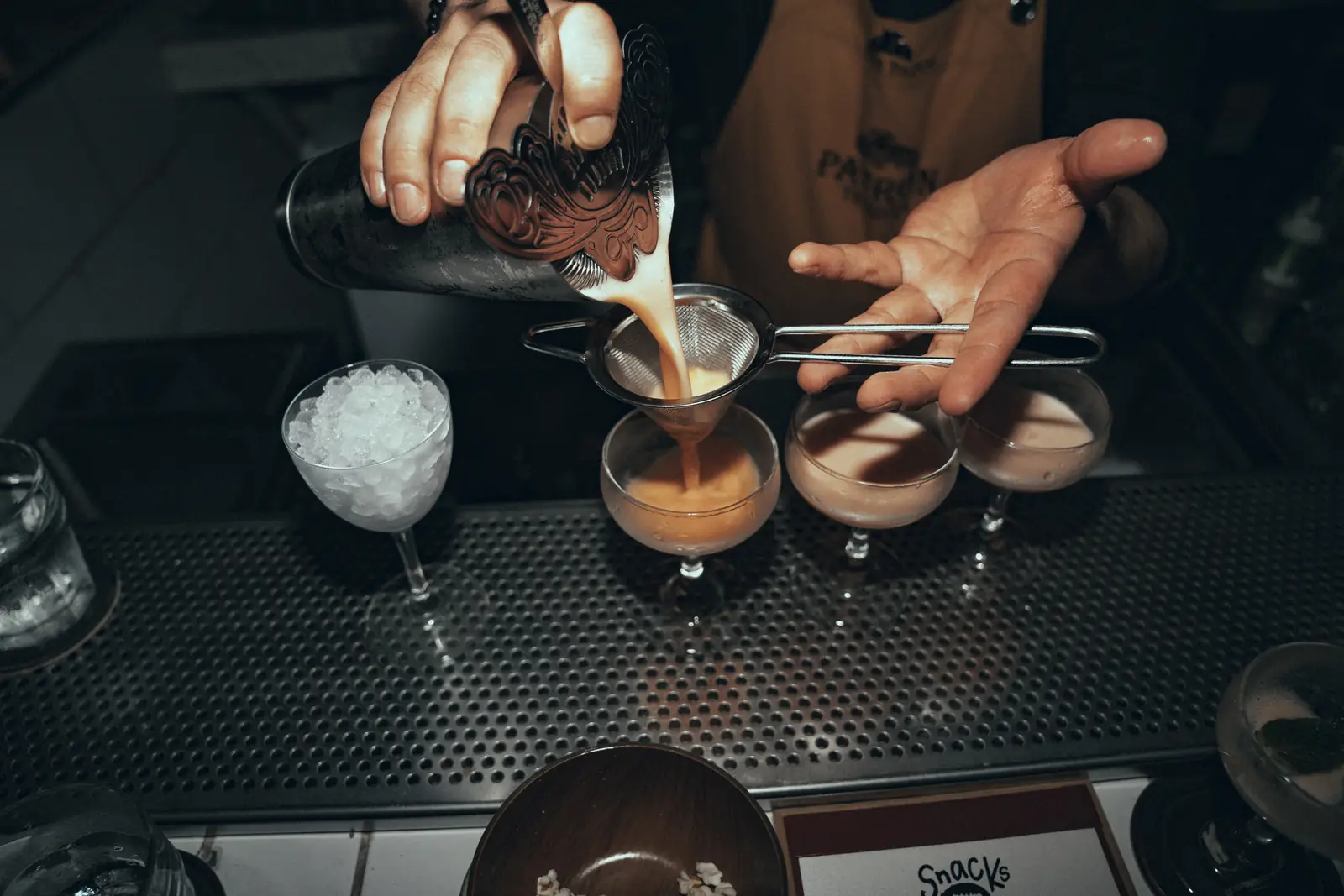 Bartender sirviendo a través de un colador